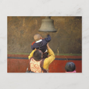 Postal monje budista tibetano levantando a un niño para t
