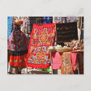 Postal Mujer peruana india mirando coloridos textiles