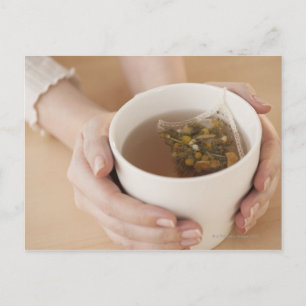 Postal Mujer sosteniendo una taza con té chamomile