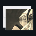 Postal Paisaje Calgary de tono sepia a través del Puente<br><div class="desc">Esta fotografía en blanco y negro captura el paisaje de la ciudad de Calgary visto a través de la estructura del moderno Puente de la Paz. El diseño del puente presenta elementos metalizado curvados que enmarcan el paisaje urbano. En el fondo, un río fluye frente a un grupo de edificios...</div>