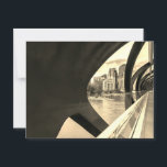 Postal Paisaje Calgary de tono sepia a través del Puente<br><div class="desc">Esta fotografía en blanco y negro captura el paisaje de la ciudad de Calgary visto a través de la estructura del moderno Puente de la Paz. El diseño del puente presenta elementos metalizado curvados que enmarcan el paisaje urbano. En el fondo, un río fluye frente a un grupo de edificios...</div>