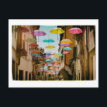 Postal Paraguas flotantes<br><div class="desc">Paraguas extravagantes flotando sobre una calle.</div>