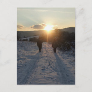 Postal Pareja caminando en la nieve al atardecer