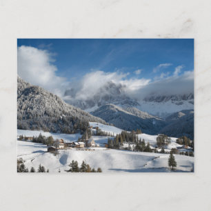 Postal Pequeño pueblo con montañas Dolomitas en la nieve