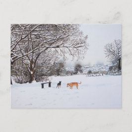 Postal perros jugando en un paisaje nevado en navidades