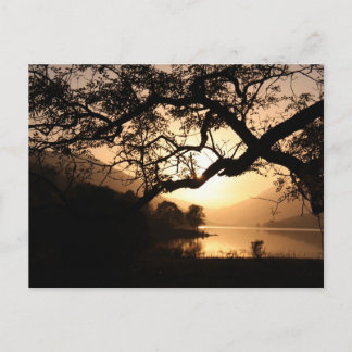 Postal Sunset escocés a través de un lago