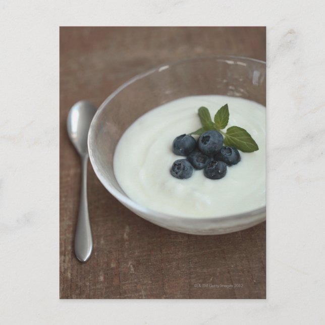 Postal Tazón de yogur con arándano sobre la mesa (Anverso)