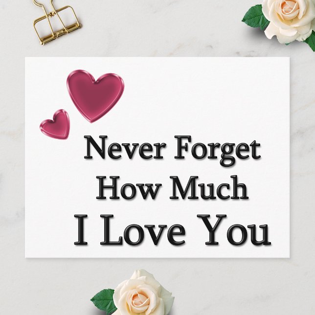 Postal Te Amo (Postcard showing Never Forget How Much I Love You with two hearts, laid flat on a white surface.)