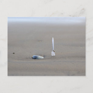 Postal tenedor de plástico pegado a la playa de arena