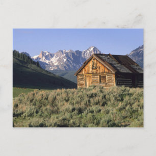 Postal Una cabaña de troncos y las montañas Sawtooth en