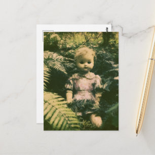 Postal Una muñeca espeluznante abandonada en el bosque