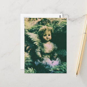 Postal Una muñeca espeluznante linda abandonada en el bos