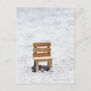 Postal Una pequeña silla en la playa de arena