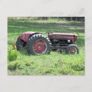Postal Viejo dañado poco tractor en un campo