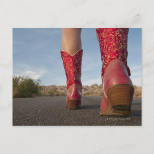 Postal Vista en ángulo bajo de la mujer con botas de vaqu