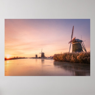 Póster Amanecer sobre río congelado con molinos de viento