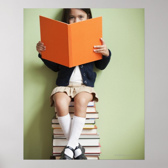 Póster Chica de raza mixta sentada en una pila de libros (Frente)