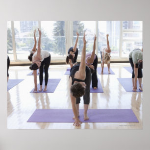 Póster class practicing yoga with instructor in a