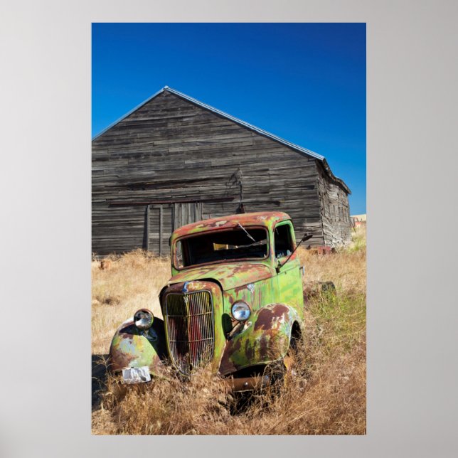 Póster Coche oxidándose frente a una granja abandonada (Frente)