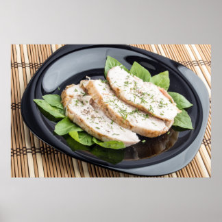 Póster Cortes al horno de carne de pollo en un plato negr