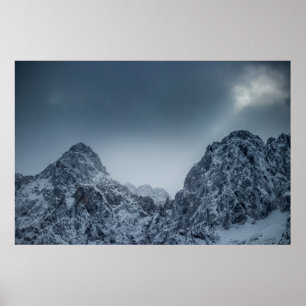 Póster Luz solar y nubes oscuras sobre montañas nevadas