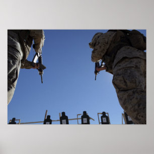Póster Marines change magazines in the midst of firing