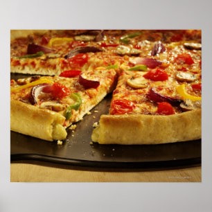 Póster pizza vegetal cortada en una sartén negra en mader