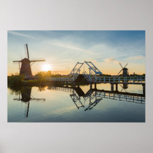 Póster Puente levadizo y molinos de viento al atardecer e