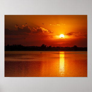 Póster Puesta de sol naranja dorada sobre un lago tranqui