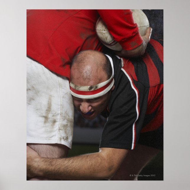 Póster Rugby player tacking opponent, mid section (Frente)