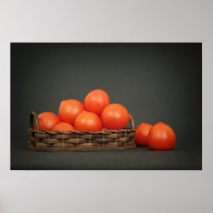 Póster Tomates rojos pequeños en una cesta sobre una mesa