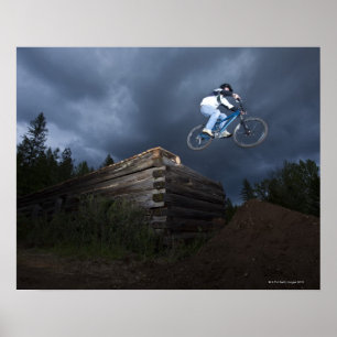 Póster Un ciclista de montaña salta de una cabaña de made
