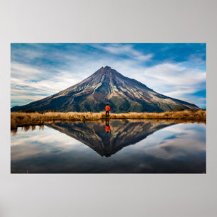 Póster Un montañista con un vestido naranja en una simetr