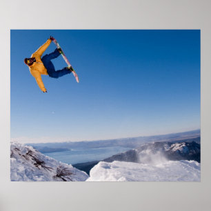 Póster Un snowboarder hace girar apagado un salto en la