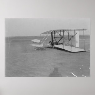 Póster Wilbur Wright en un avión dañado después