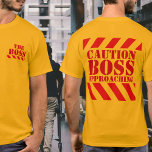 Precaución BOSS tiras de advertencia de camisetas<br><div class="desc">Camiseta de advertencia. Camiseta del jefe divertido. Lecturas en frente El jefe en la espalda advierte al jefe acercarse. Un gran regalo para un fiesta secreto de Navidad en la oficina de santa, o como una broma al jefe si eres lo suficientemente valiente, por supuesto. Diseñado exclusivamente por Sarah Trett....</div>