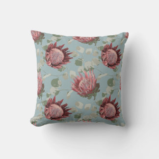 Protea verde y rosa sobre almohada azul francesa