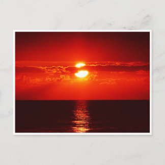 Puesta de sol roja brillante sobre la tarjeta post