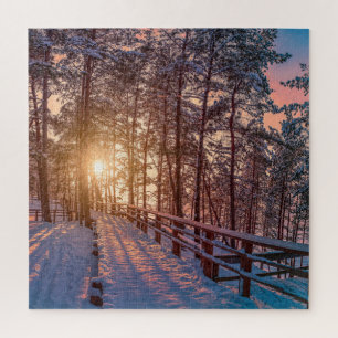 Puzzle Atardecer en un bosque de pinos nevado con rayos s