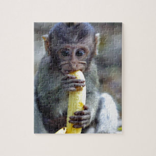 Puzzle Bebé mono macaco lindo comiendo plátano