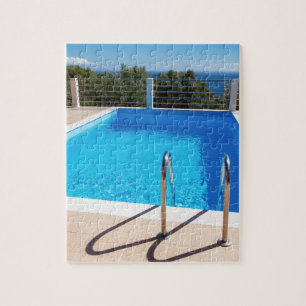 Puzzle Piscina azul con pasos en el mar