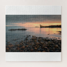 Sunset de rock negro en la playa Salthill en Galwa