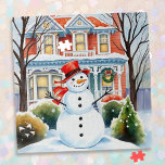 Puzzle Un caprichoso y caprichoso hombre de nieve en los<br><div class="desc">Un bonito ilustracion acuático de un muñeco de nieve frente a una casa victoriana suburbana en un barrio acogedor y agradable.</div>