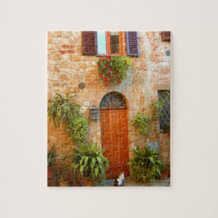 Puzzle Un gato busca entrada a casa en Pienza, Italia.