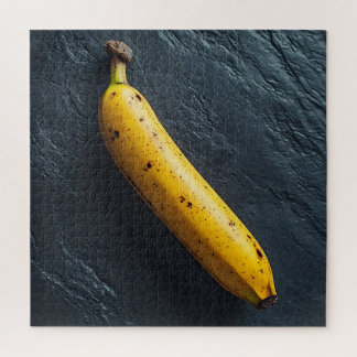 Puzzle Una banana en una superficie oscura