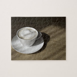 Puzzle Una taza de café del cappuccino miente en un robl