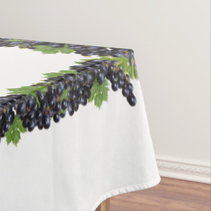 Ramas de uvas de vino tinto sobre mantel blanco
