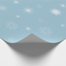 Copos de nieve en el papel de embalaje azul claro