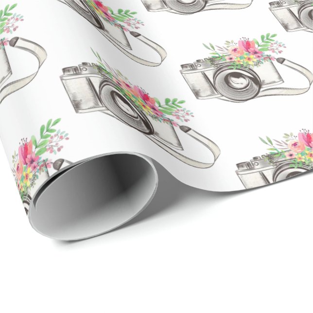 Regalo Flores y cámara sobre papel de envolver blanco (Esquina del rollo)