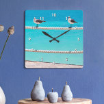 Reloj Cuadrado Aves de gaviota blanca en una foto azul turquesa d<br><div class="desc">Hay buenas vibraciones por todas partes cada vez que revisas la hora en este colorido reloj de pared fotográfico. Las gaviotas grises, blancas y alegres se relajan en una valla de cuerda frente al océano turquesa y vibrante. ¡Hace un gran regalo de bienvenida! Puede personalizar fácilmente este reloj de pared....</div>